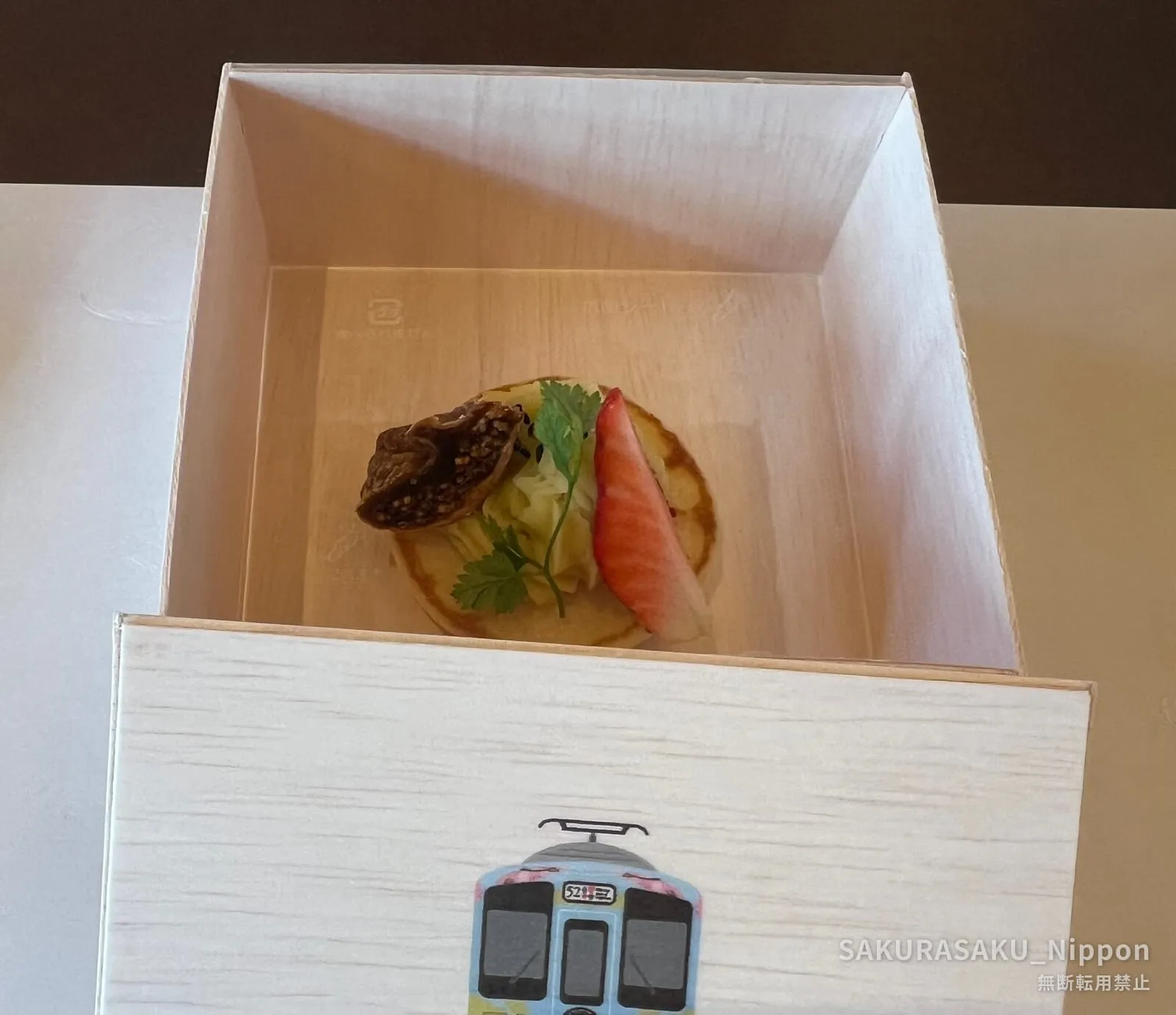 A delicate amuse-bouche served inside the wooden "52 Seats" box