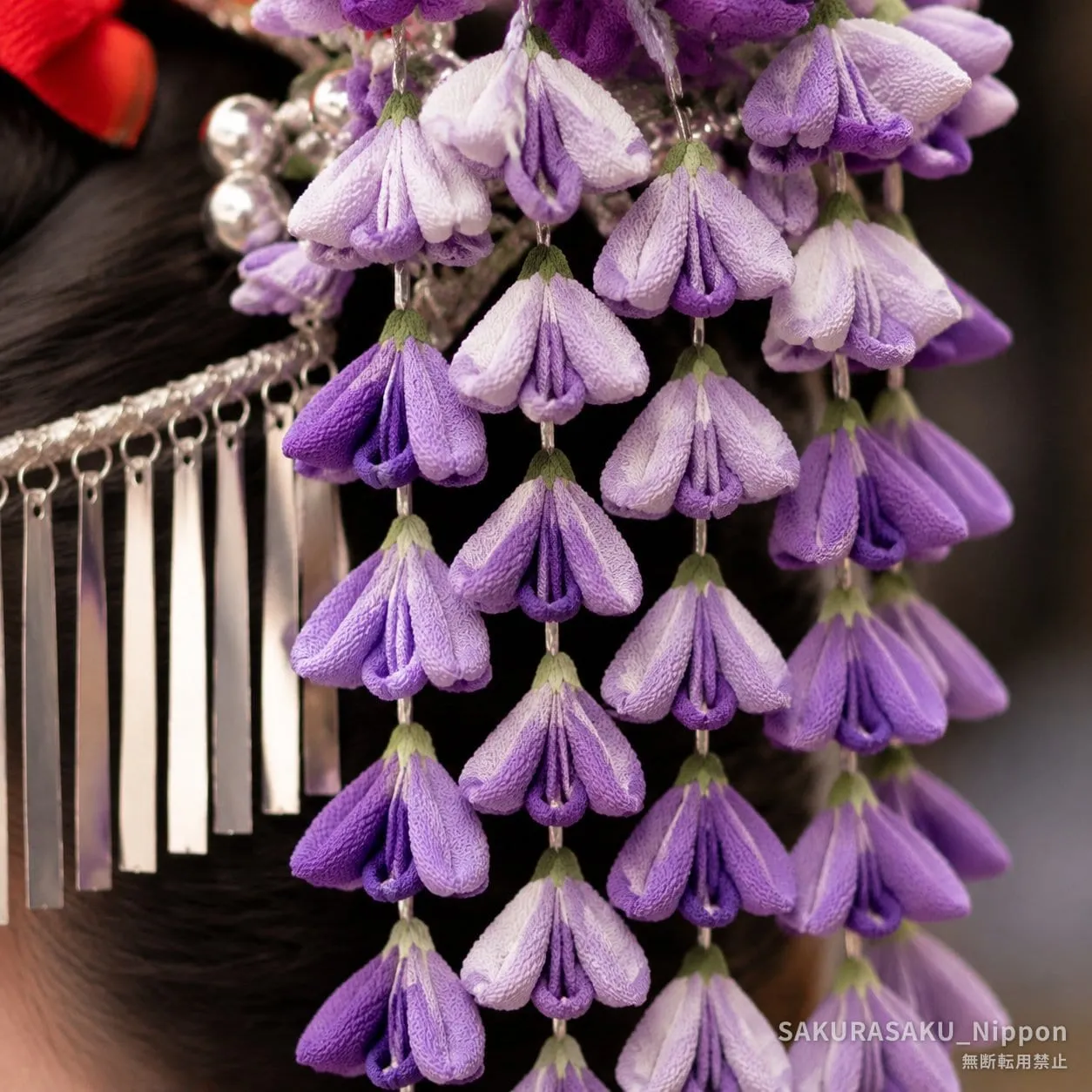 Wisteria hana-kanzashi — a maiko's silk flower hairpin, its dyed blossoms cascading just as the real wisteria falls