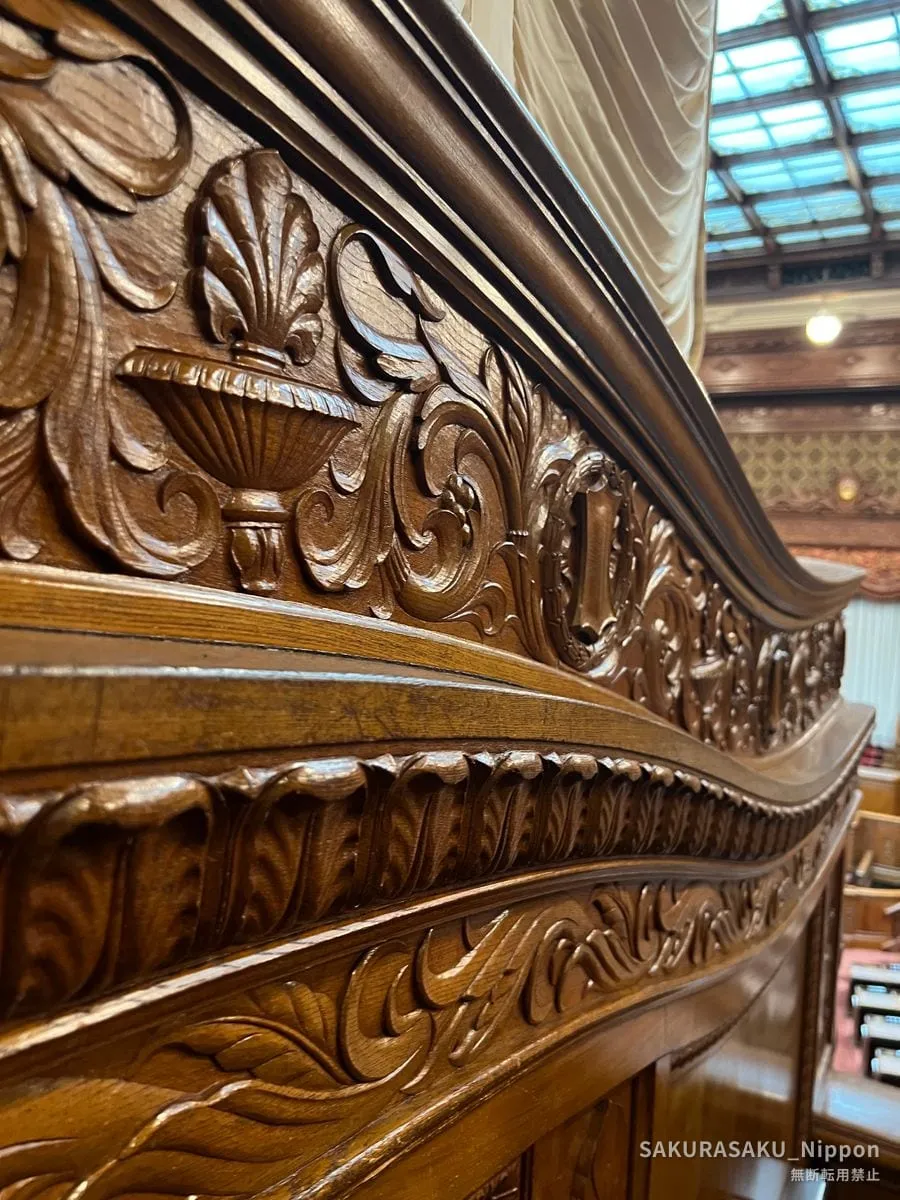 Hand-carved wooden balustrade with leaves and scrolls in the chamber