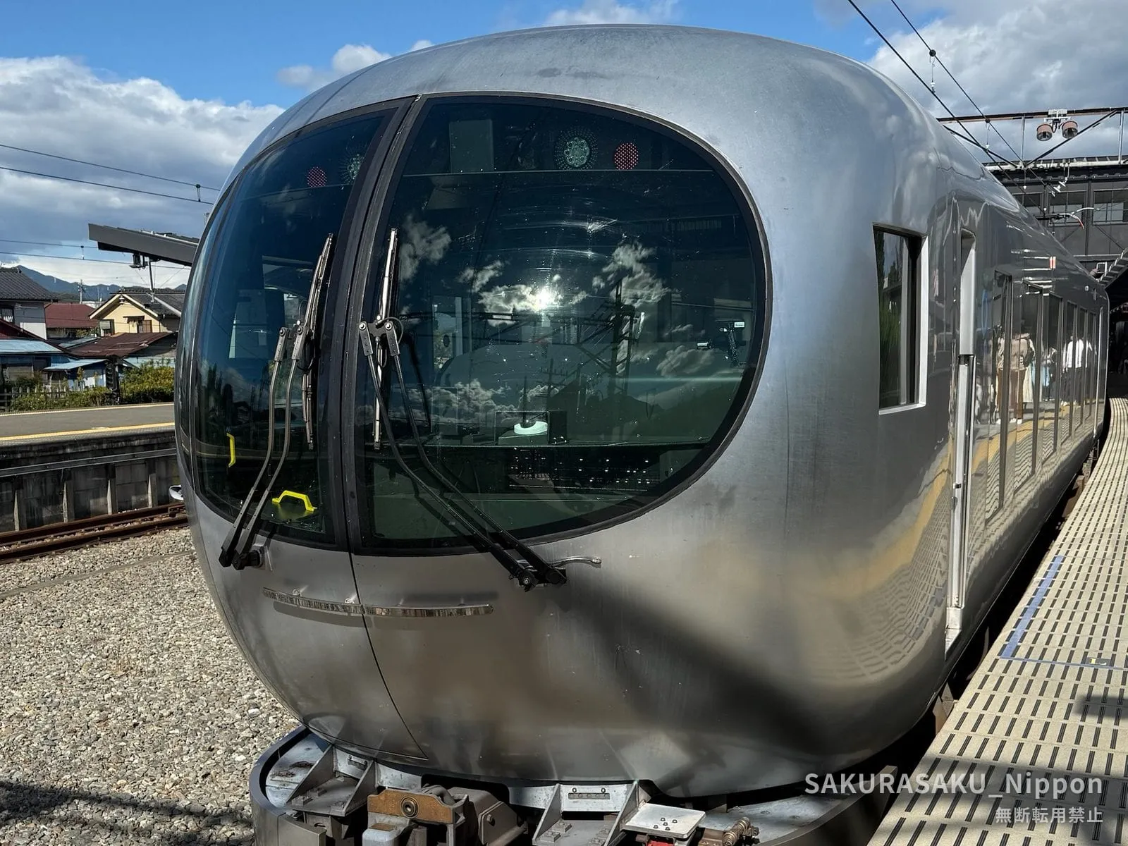 The rounded silver nose of the Seibu Laview limited express, waiting at a platform in the hills