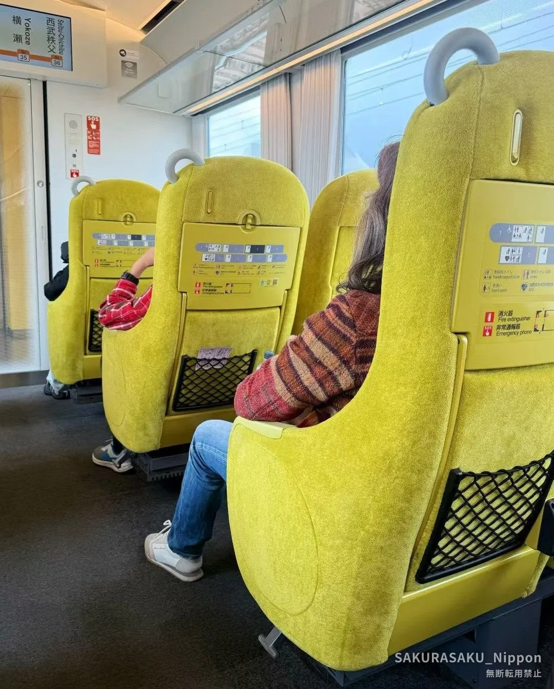 Yellow Laview seats and the huge windows, with the display showing the last stops before Seibu-Chichibu