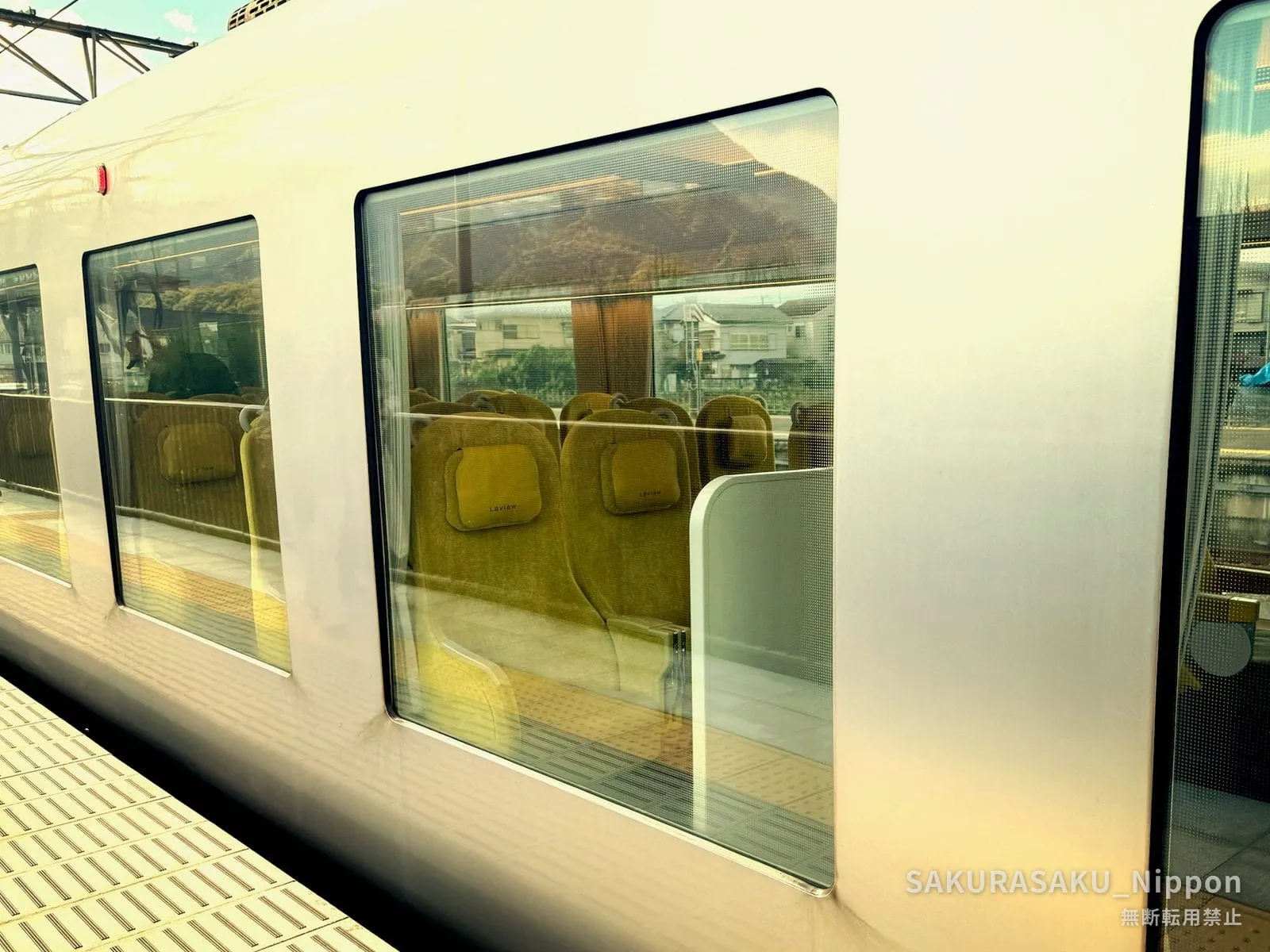 The enormous side windows of the Laview, with its yellow seats inside and the view showing through the carriage