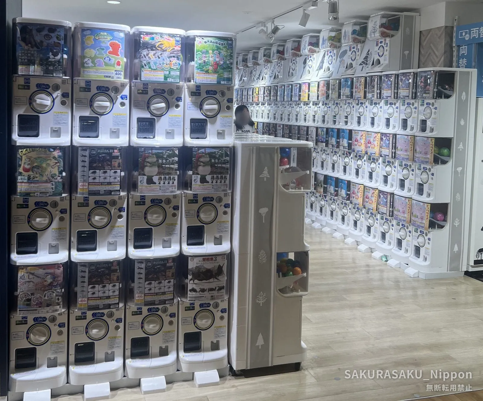 Rows of capsule toy machines stacked several tiers high, running the length of a shop in Subnade