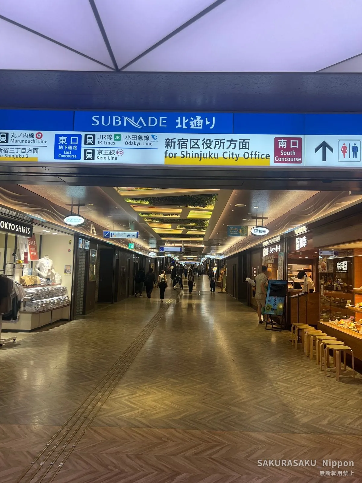 A Subnade sign reading Kita-dori and for Shinjuku City Office, above a quiet shopping corridor
