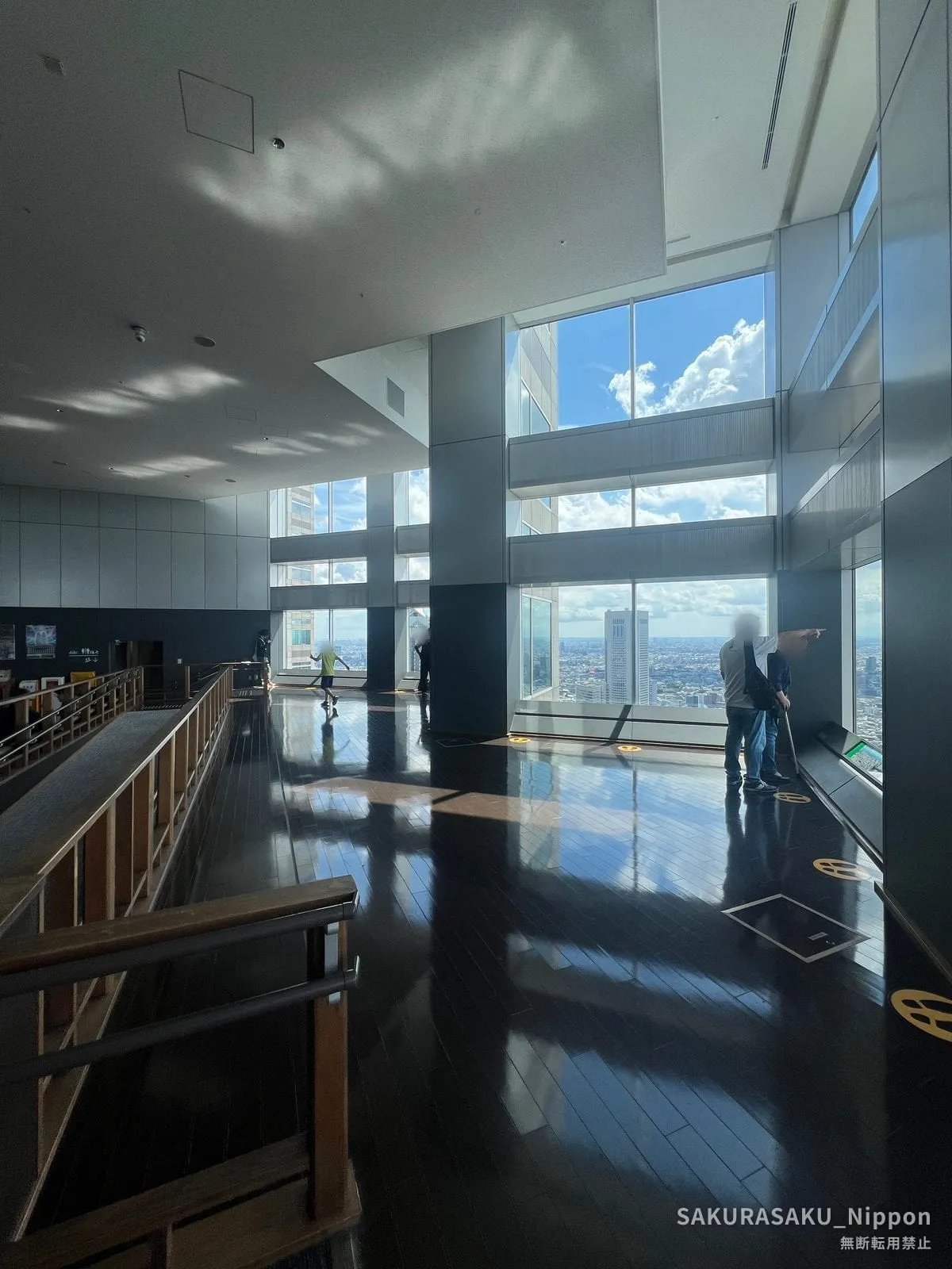 Inside the observatory: light reflecting off the polished floor, with the city spread out beyond the tall windows