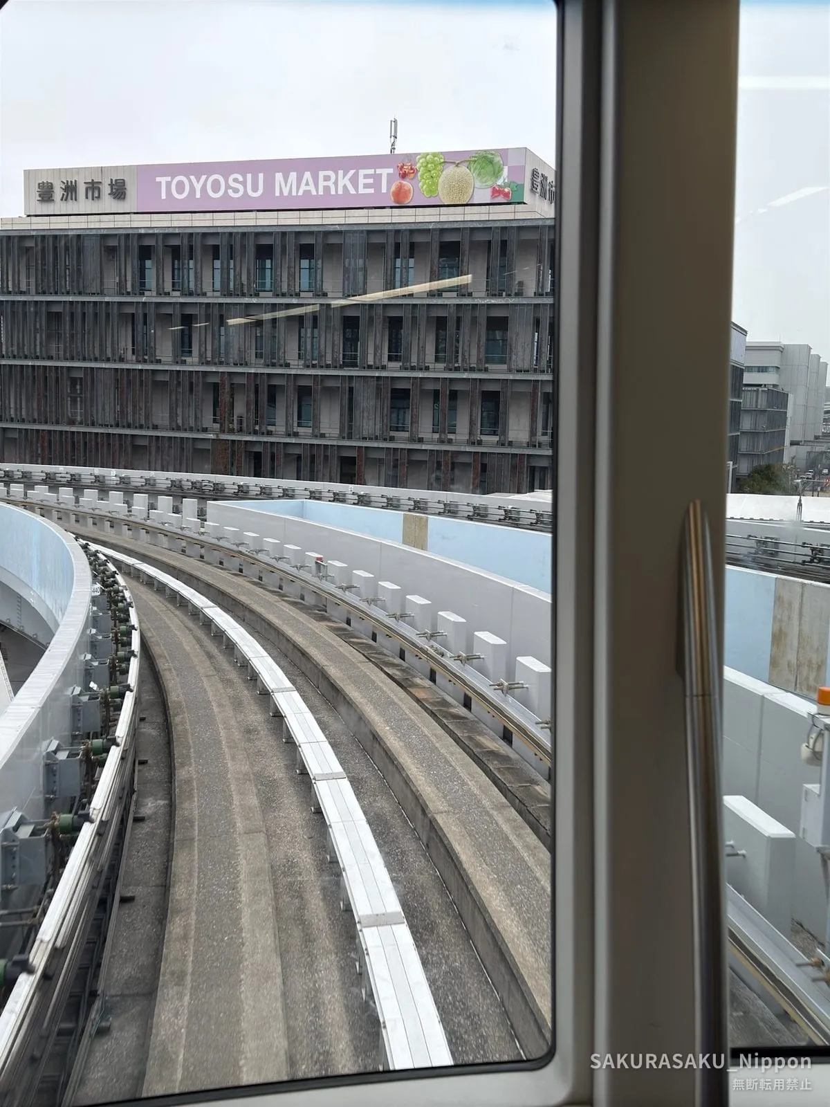 The Yurikamome line approaching Toyosu Market, with the market's sign above the tracks