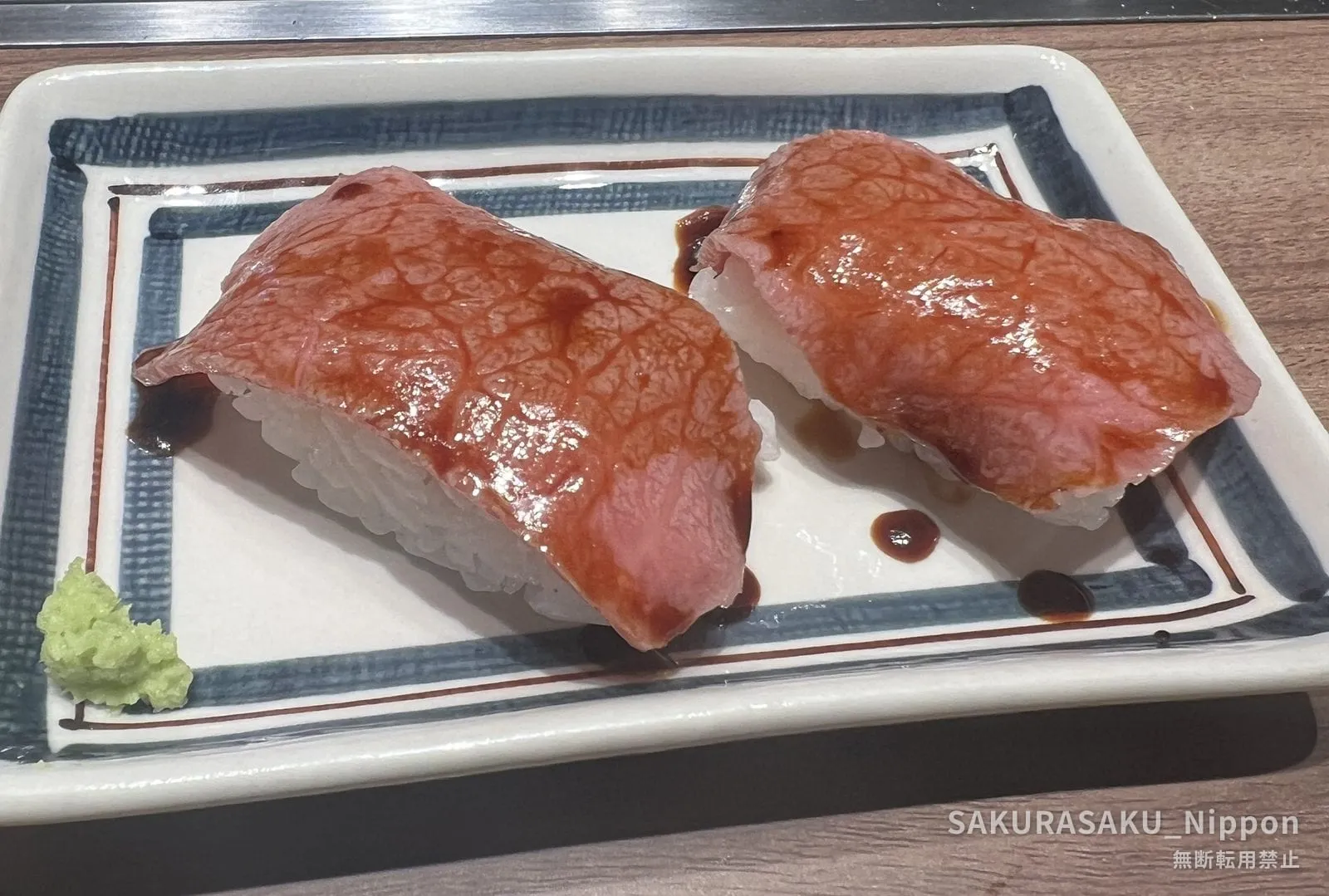 Two pieces of wagyu beef sushi on a plate